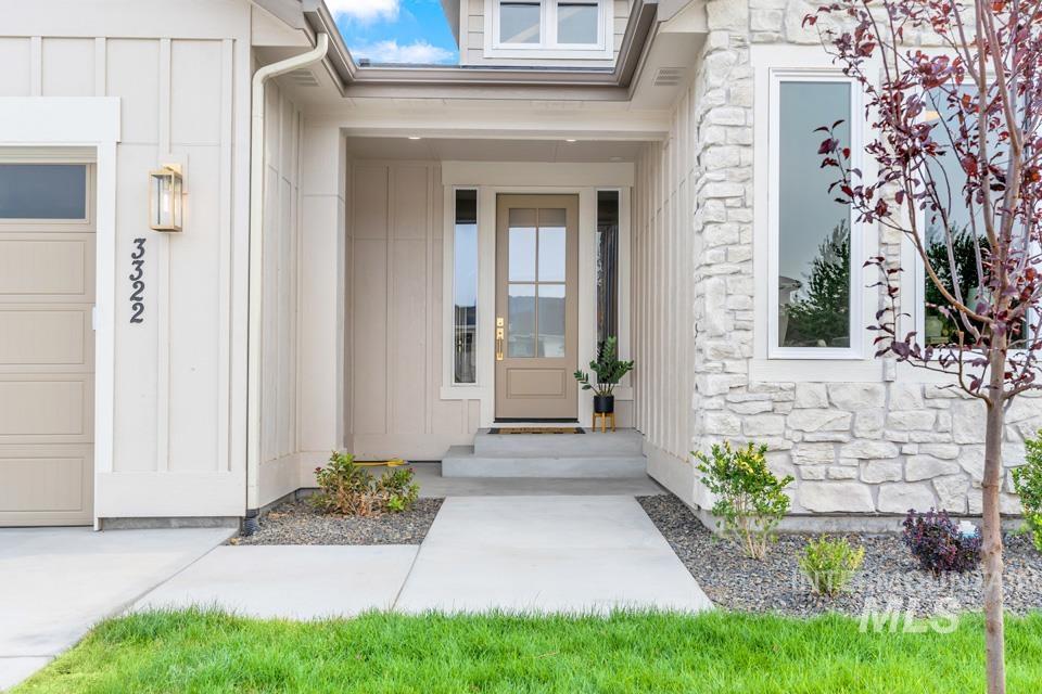 3322 South Volunteer Place Meridian, ID 83642 - Photo 3 of 50 Entrance to property with stone siding, board and batten siding, and a garage