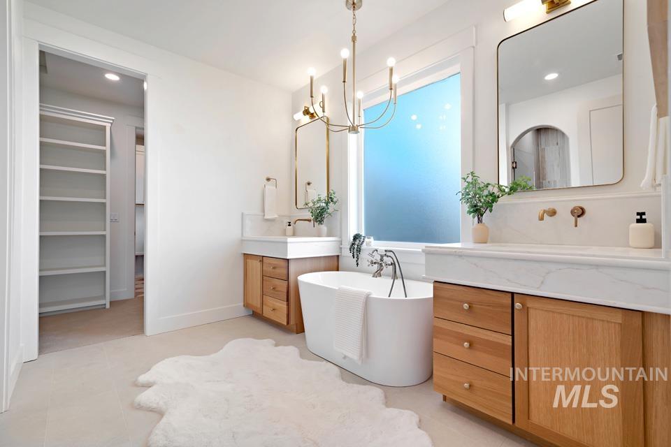 3322 South Volunteer Place Meridian, ID 83642 - Photo 33 of 50 Bathroom featuring a freestanding tub, two vanities, a chandelier, and recessed lighting