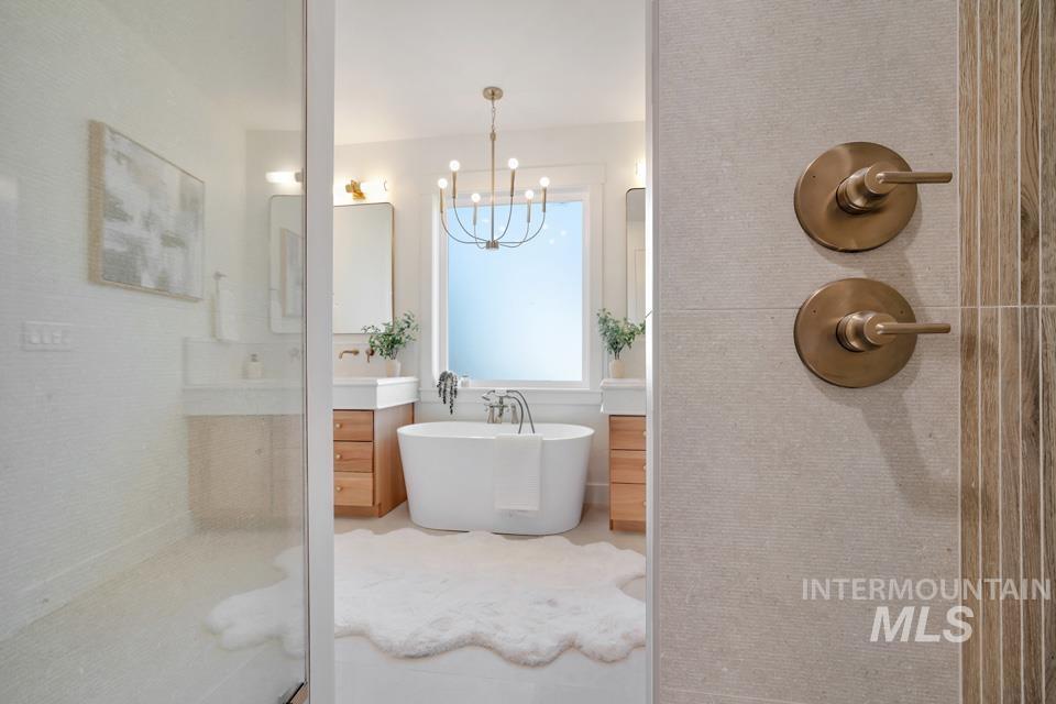 3322 South Volunteer Place Meridian, ID 83642 - Photo 39 of 50 Full bathroom featuring vanity, a soaking tub, a shower stall, and a chandelier