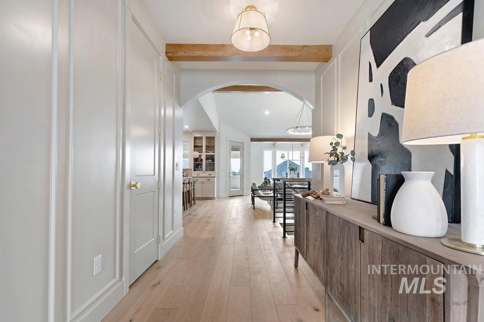 3322 South Volunteer Place Meridian, ID 83642 - Photo 4 of 50 Corridor featuring arched walkways, light wood-style flooring, and beamed ceiling
