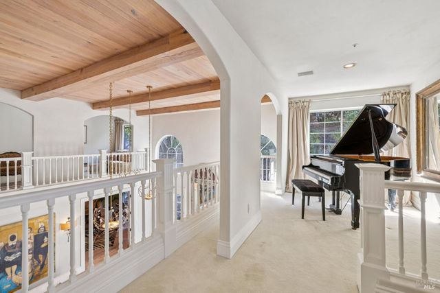 a dining room with furniture large windows and a chandelier