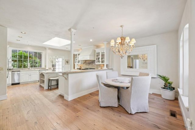 a dining room with furniture a chandelier and wooden floor