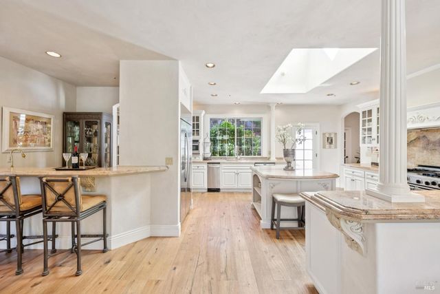 a living room with furniture a large window and wooden floor