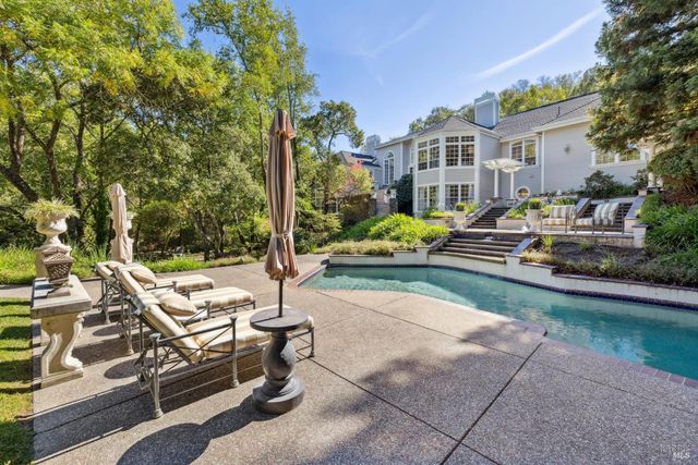 a view of a house with backyard and sitting area