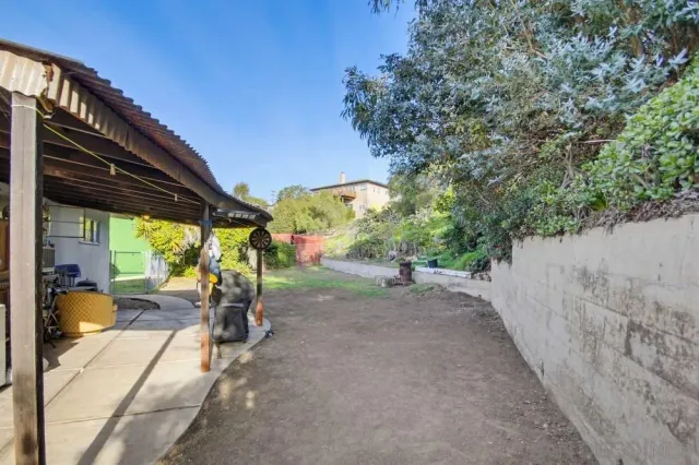 a view of a house with backyard and sitting area