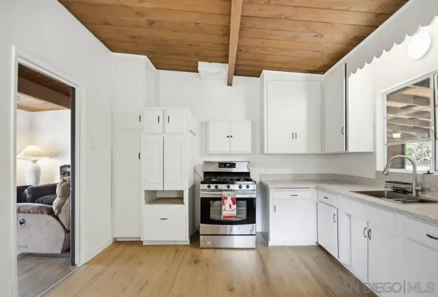 a kitchen with stainless steel appliances granite countertop a stove and white cabinets