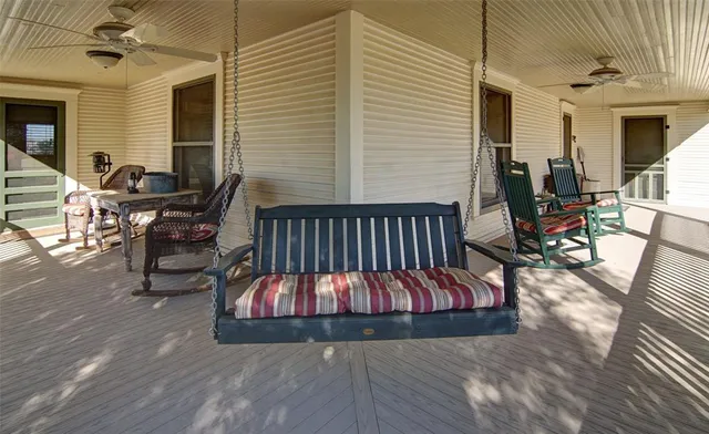 a view of a patio with table and chairs with wooden floor and fence