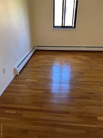 a view of a room with wooden floor and window
