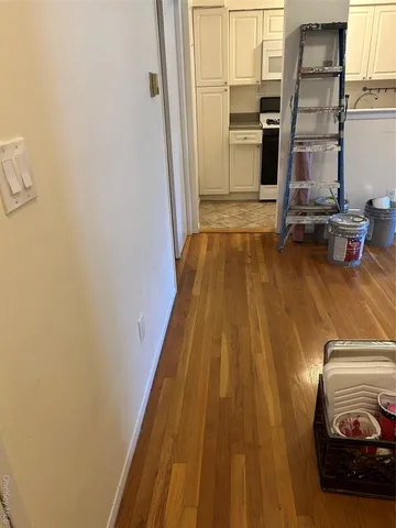 a view of a bedroom with wooden floor and windows