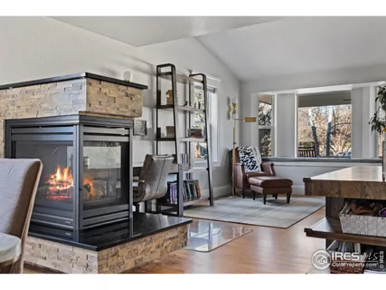 a living room with furniture a fireplace and large window