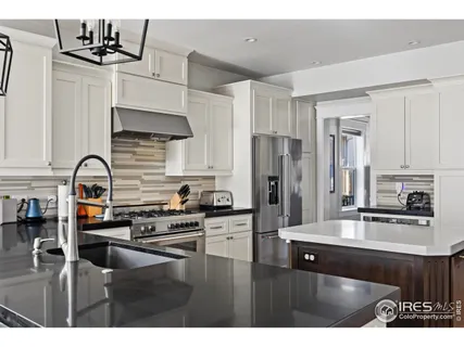 a kitchen with a kitchen island stainless steel appliances and a chandelier