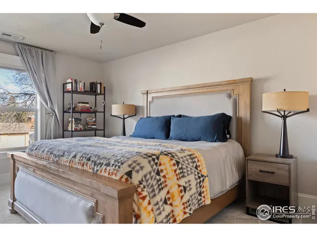 a bedroom with a bed and a painting on the wall