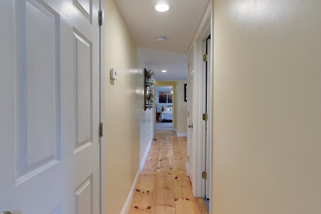 384 Richardson Road Ashby, MA 01431 - Photo 14 of 40 a view of a hallway with wooden floor and a bathroom