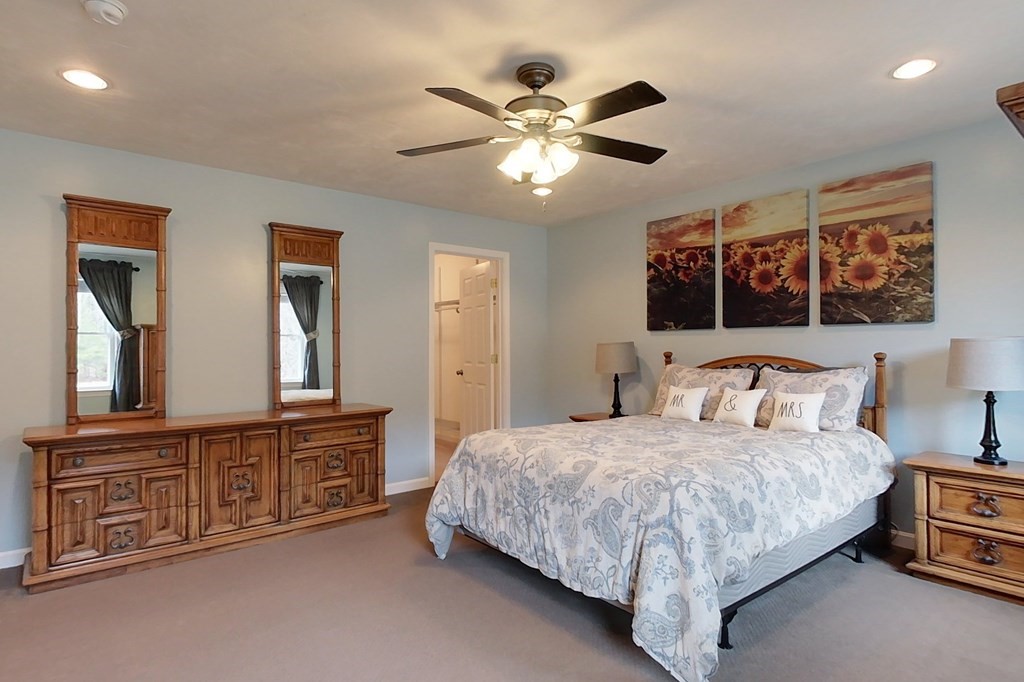 384 Richardson Road Ashby, MA 01431 - Photo 25 of 40 a bedroom with a large bed and a chandelier