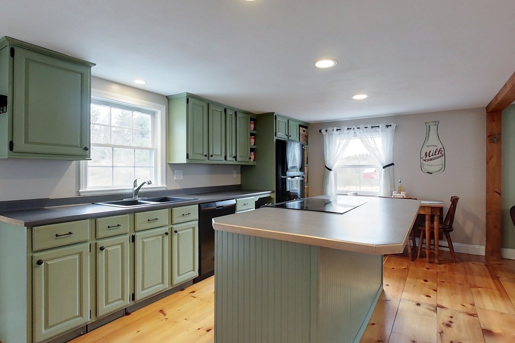 384 Richardson Road Ashby, MA 01431 - Photo 3 of 40 a kitchen with kitchen island granite countertop a sink a stove cabinets counter space and a window