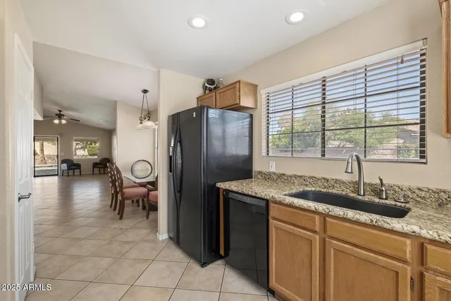 a kitchen with stainless steel appliances granite countertop a sink and a refrigerator