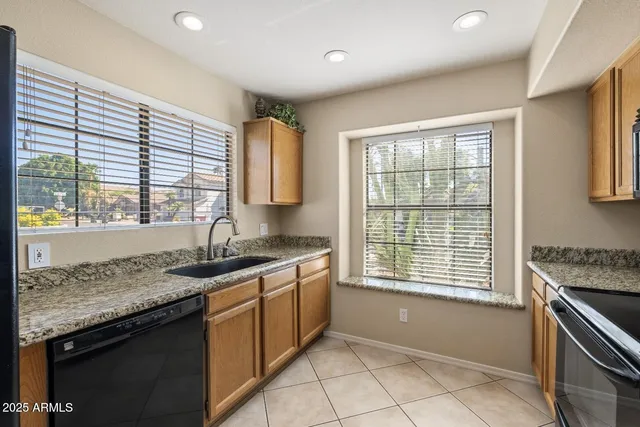 a kitchen with granite countertop sink stove and cabinets