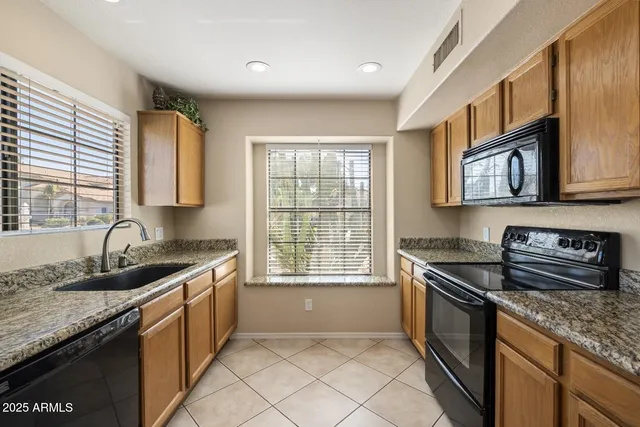a kitchen with stainless steel appliances granite countertop a sink stove and cabinets