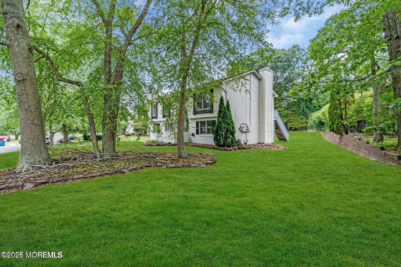 88 Hickory Hill Road Jackson, NJ 08527 - Photo 4 of 21 a view of a white house with a small yard and large trees