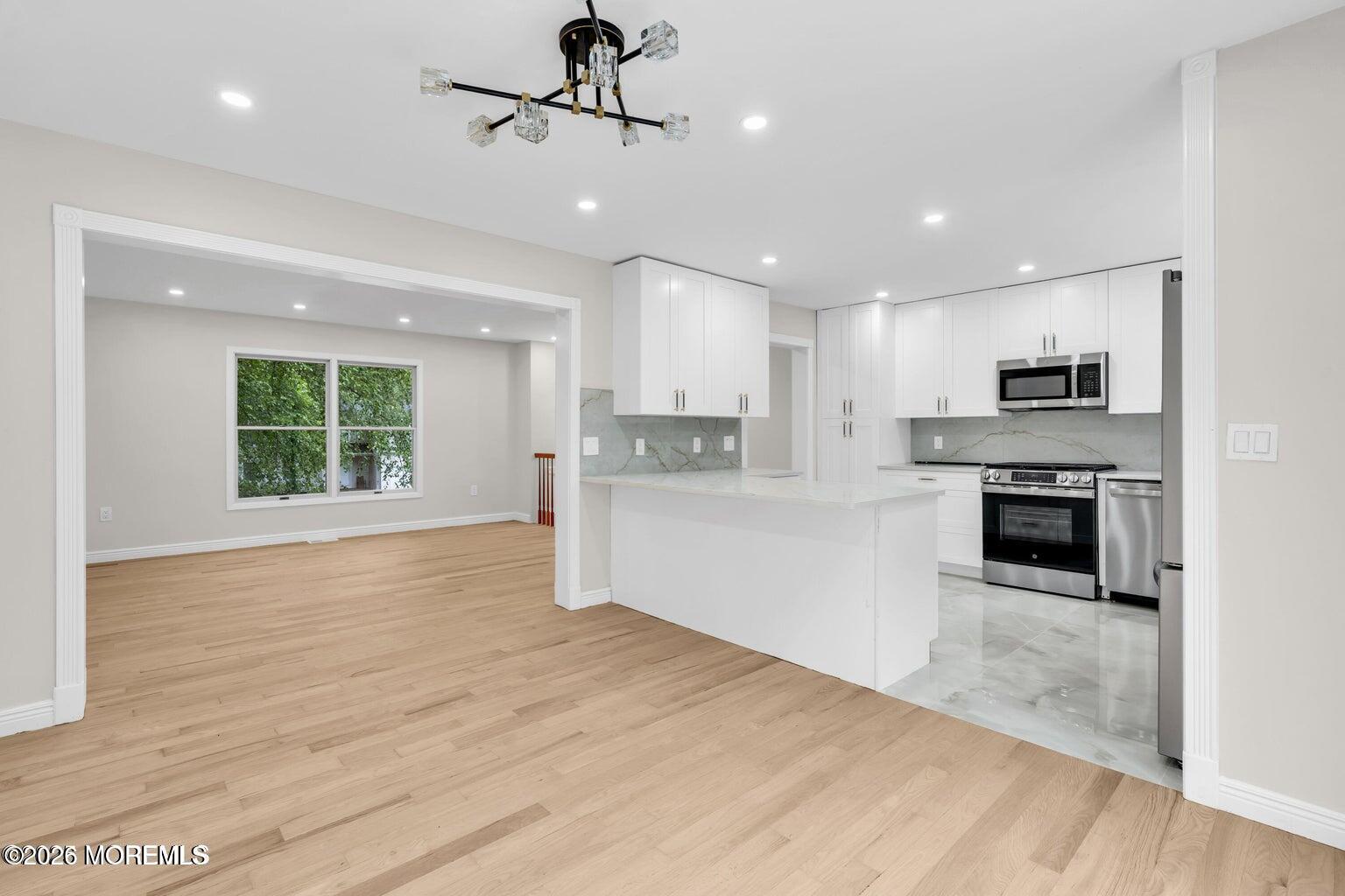88 Hickory Hill Road Jackson, NJ 08527 - Photo 6 of 21 a large kitchen with stainless steel appliances granite countertop a stove a refrigerator and a sink with wooden floor