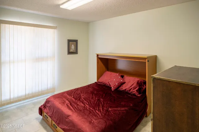 a bed sitting in a bedroom next to a window