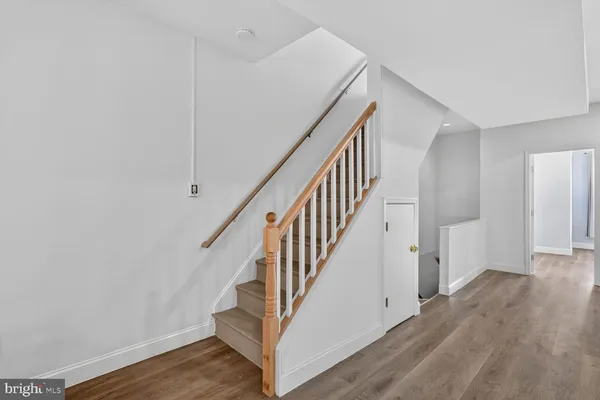 a view of staircase with wooden floor and white walls