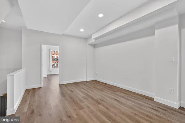 a view of an empty room with wooden floor