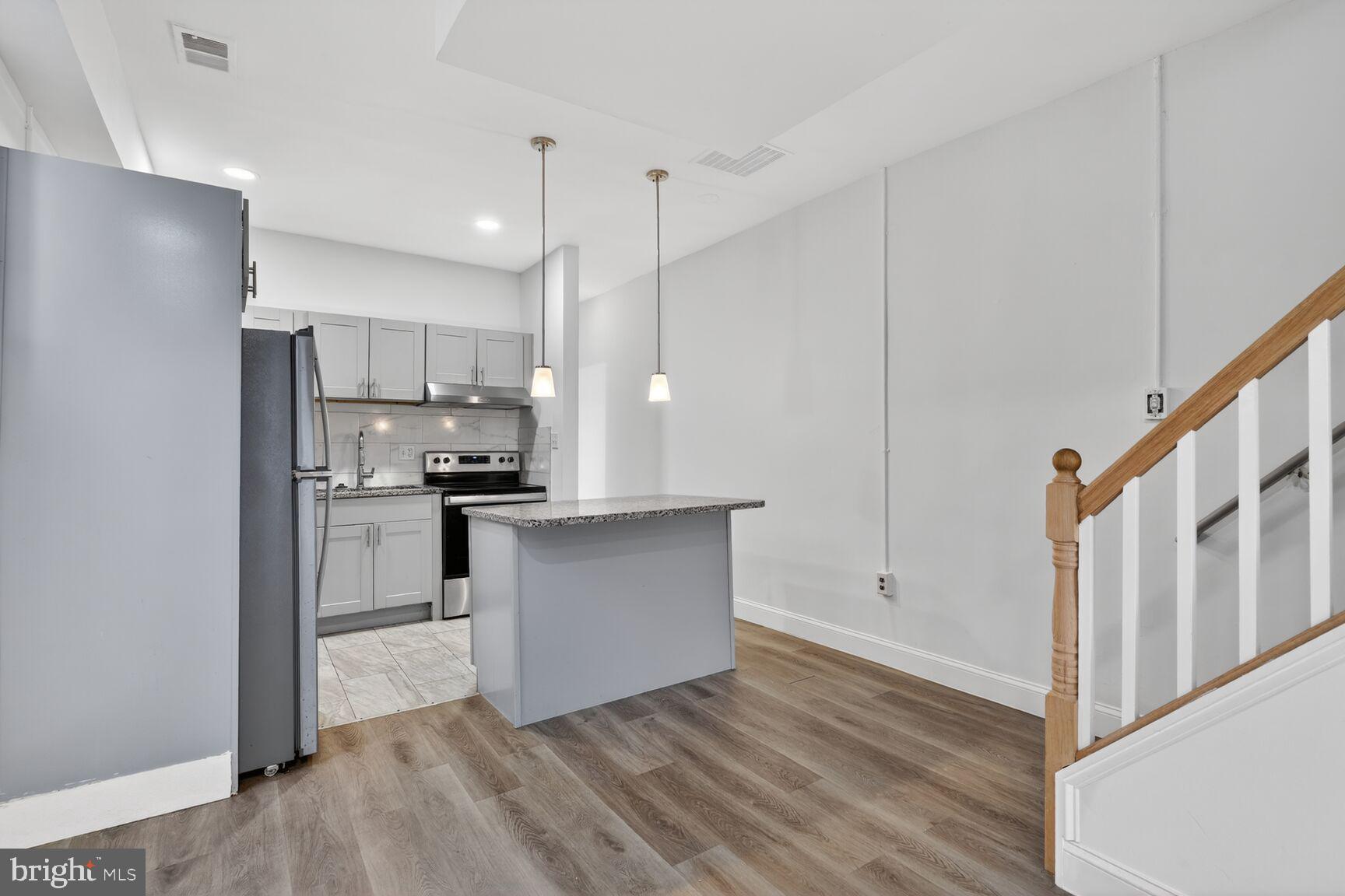 2409 18th Street Northwest, Unit 2 Washington, DC 20009 - Photo 5 of 19 a kitchen with white cabinets and stainless steel appliances