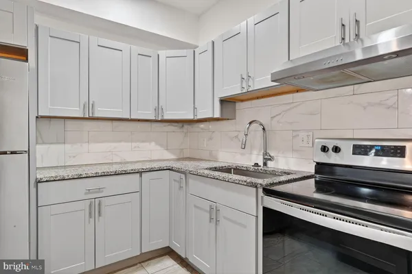 a kitchen with white cabinets appliances and sink
