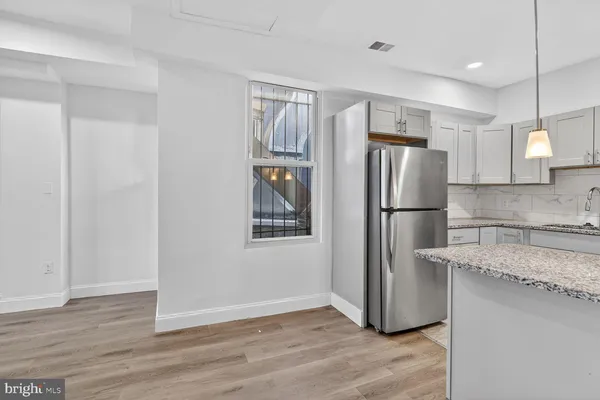 a kitchen with granite countertop a refrigerator and a sink