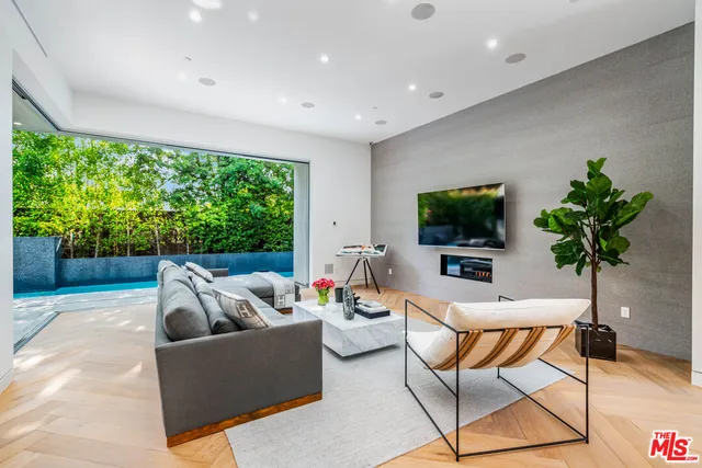 a living room with furniture a flat screen tv and a large window
