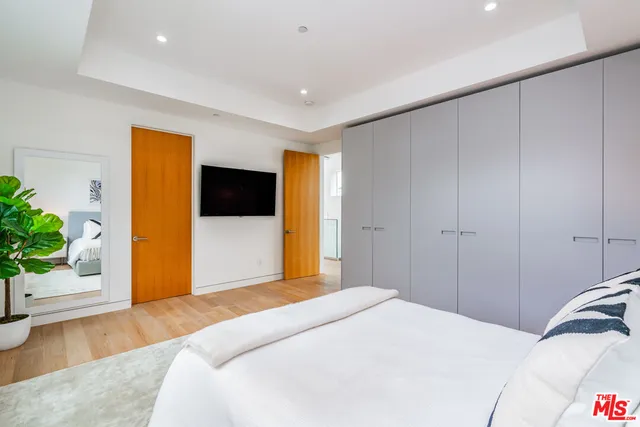 a bedroom with a bed and a potted plant