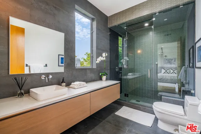 a bathroom with a double vanity sink toilet and shower