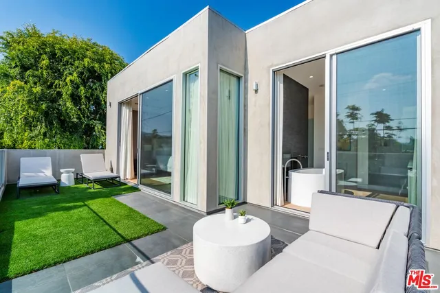 a view of a patio with couches table and chairs and potted plants