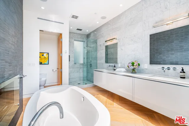 a bathroom with a tub sink and mirror