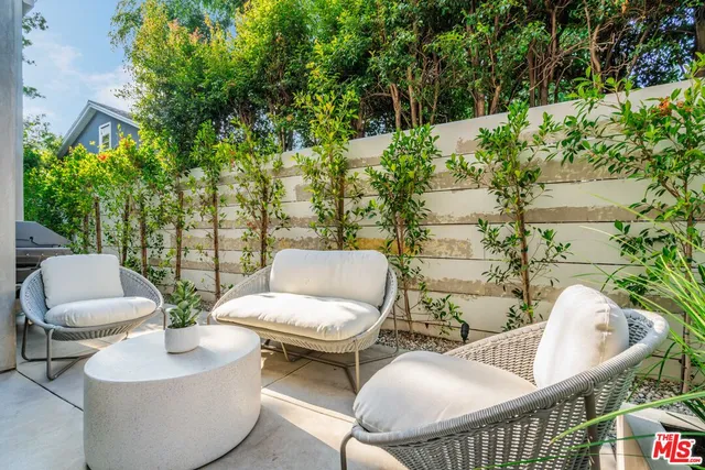a view of a patio with couches table and chairs and potted plants