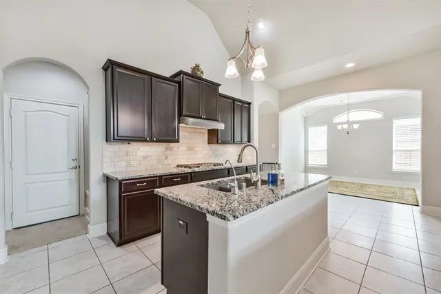 a kitchen with stainless steel appliances granite countertop a sink and a refrigerator
