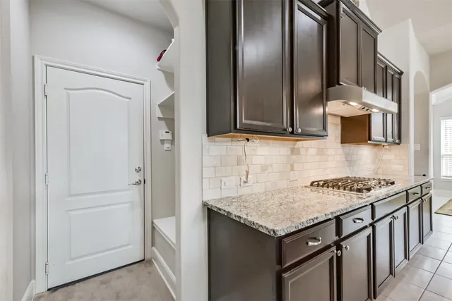 a kitchen with stainless steel appliances granite countertop a refrigerator and a stove