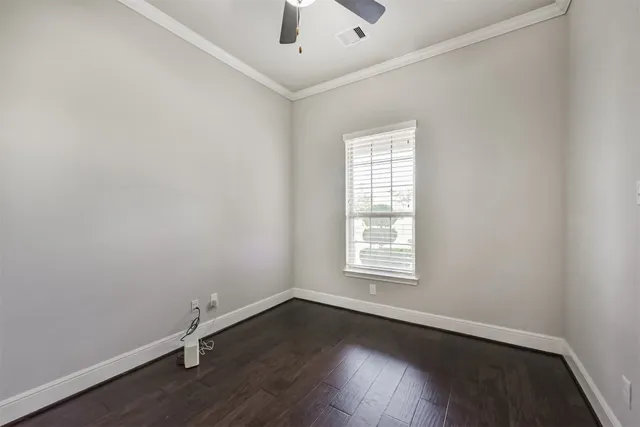 an empty room with wooden floor closet and windows