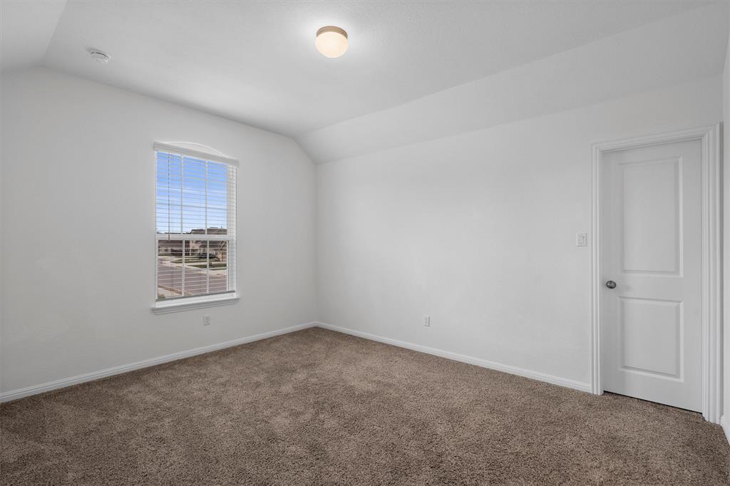 236 Prato Place Georgetown, TX 78628 - Photo 28 of 40 A well-lit bedroom features plush carpeting and ample natural light from a window with blinds.