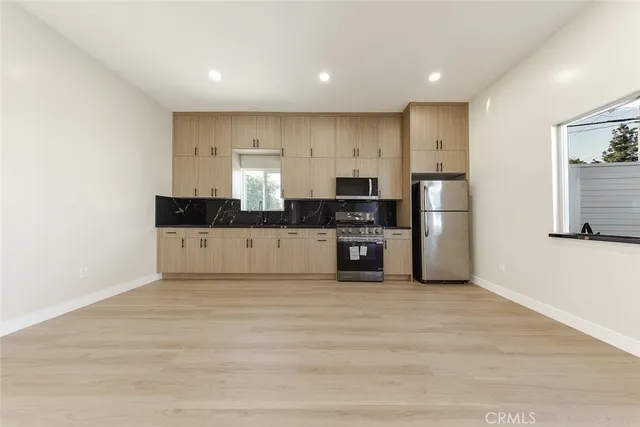 a large kitchen with cabinets and stainless steel appliances