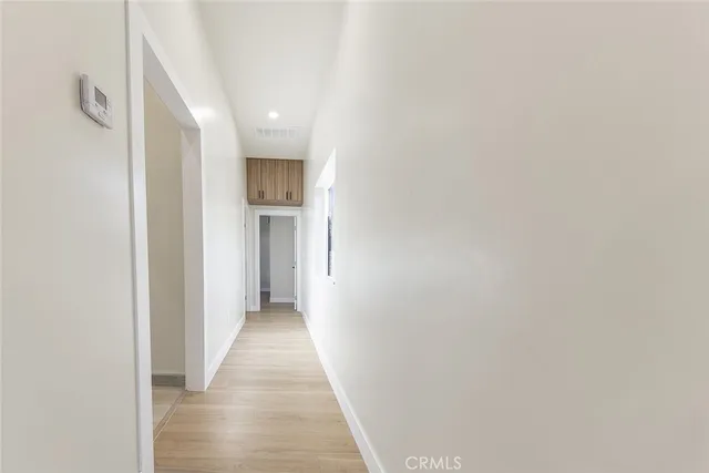 a view of a hallway with wooden floor