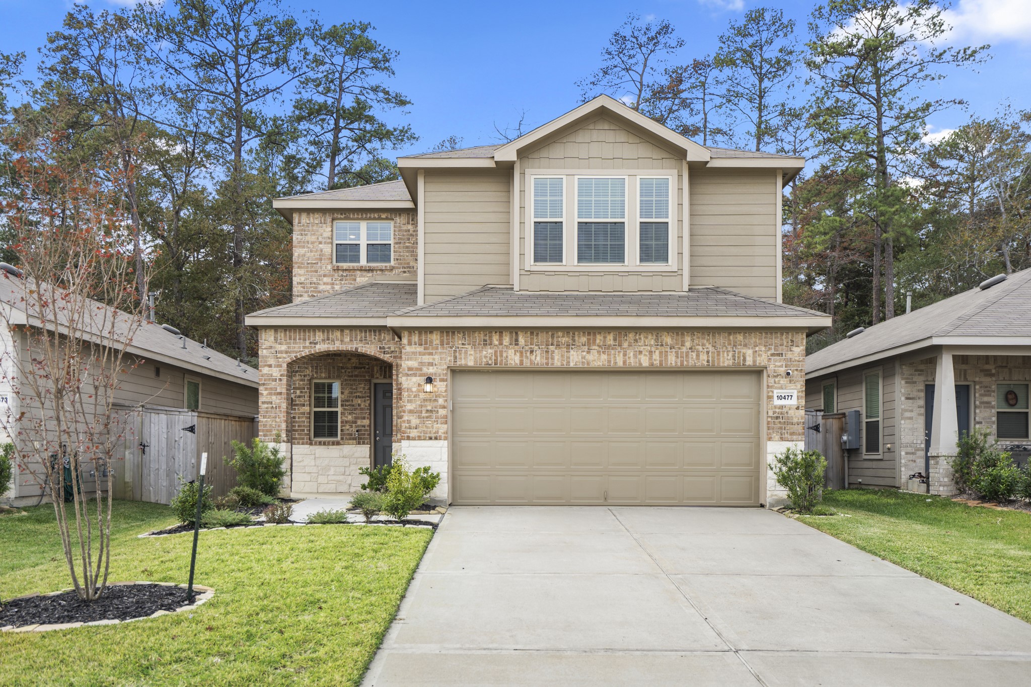 10477 Pineland Drive Willis, TX 77378 - Photo 1 of 27 a front view of a house with a yard and garage
