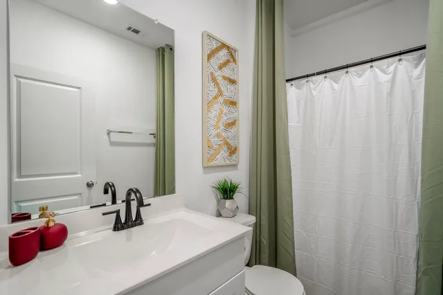 a bathroom with a sink toilet and a mirror