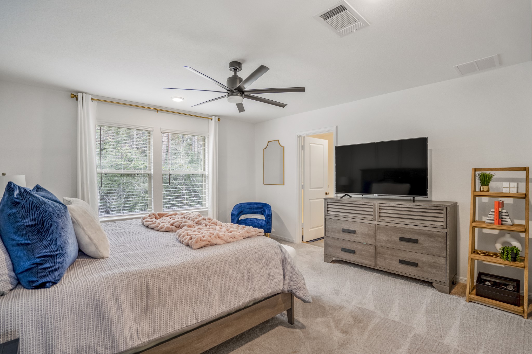 10477 Pineland Drive Willis, TX 77378 - Photo 18 of 27 a bedroom with a bed a flat screen tv and a fish tank on dresser