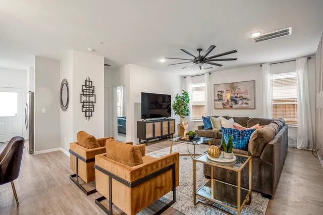 a living room with furniture a flat screen tv and a window