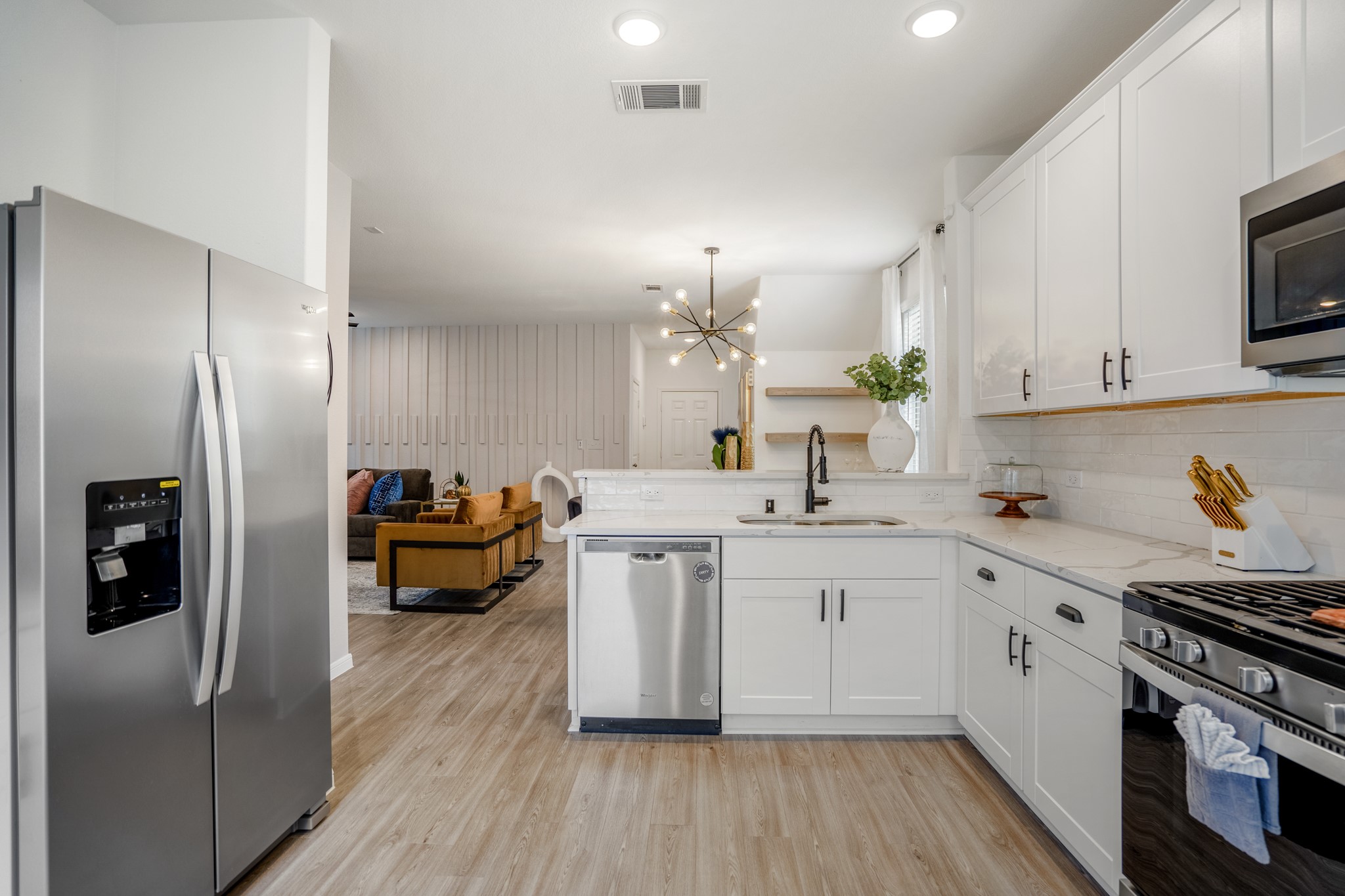 10477 Pineland Drive Willis, TX 77378 - Photo 10 of 27 a kitchen with stainless steel appliances a sink dishwasher stove refrigerator and microwave with wooden floor