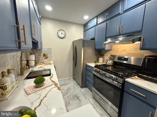 a kitchen with stainless steel appliances a stove a sink and a refrigerator