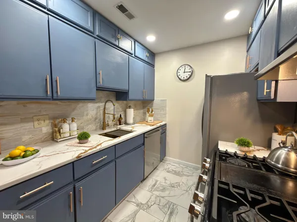 a kitchen with sink refrigerator and stove