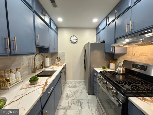a kitchen with stainless steel appliances granite countertop a stove a sink dishwasher and a refrigerator